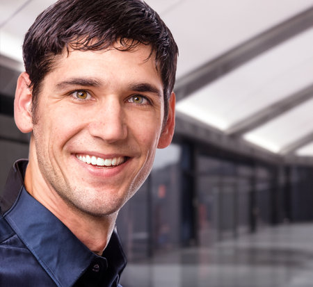Portrait of a handsome young man smiling at the camera in an office buildingの写真素材