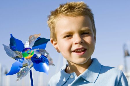 Little boy blowing on a pinwheelの写真素材