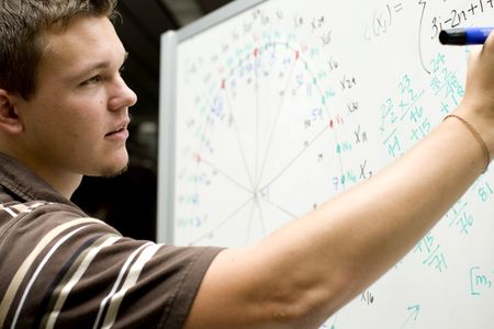 Young man at school doing a math equation