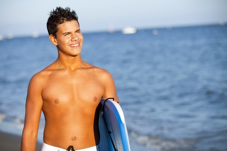 Young man at the beach with a boogie boardの写真素材