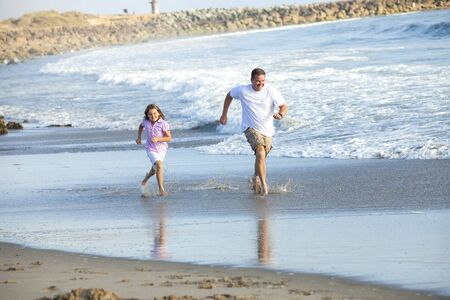 Father and daughter running at the beachの写真素材