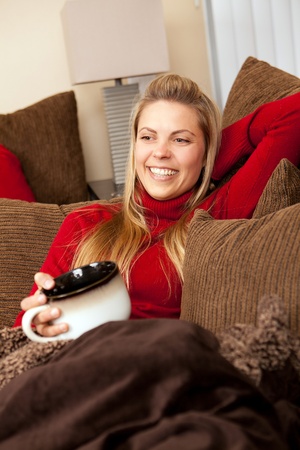 Pretty young woman lounging on a couchの写真素材