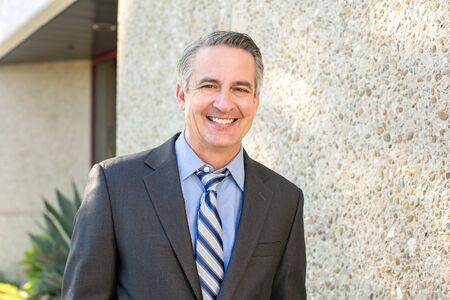 Mature happy smiling business man outside his office
