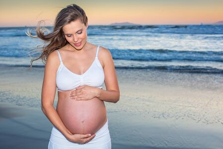 Beautiful pregnant woman at the beachの写真素材