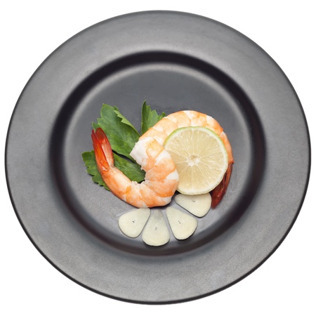 Shrimp with garlic and lime on black plate isolated on white backgorundの写真素材
