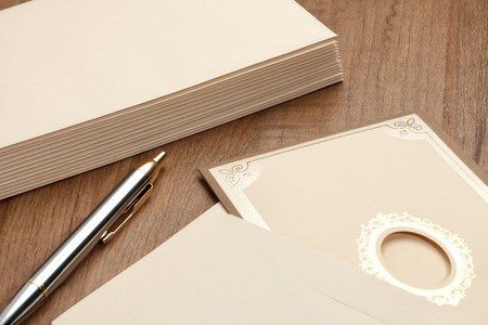 Invitation card and stack of letter on wood table