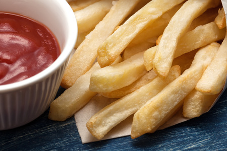 French fries with ketchup on old woodの写真素材