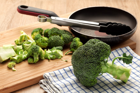 Broccoli for cooking with pan and wooden board