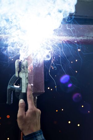 welding steel with spread spark lighting smokeの写真素材