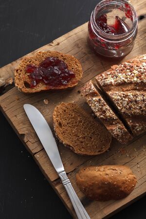Dark multigrain bread fresh baked rustic breakfast food Whole grain homemade bakery tasty fruit jam...