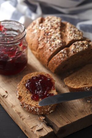Dark multigrain bread fresh baked rustic breakfast food Whole grain homemade bakery tasty fruit jam...