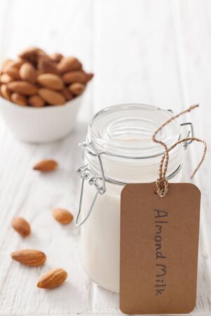 almond milk organic healthy nut vegan vegetarian drink white background wood teak rustic still life labelの写真素材