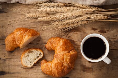 Tasty croissant coffee still life rustic wooden background bakery breakfast brunch flat layの写真素材