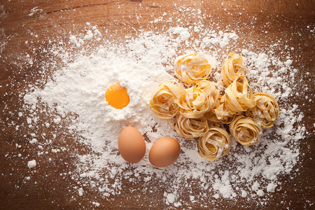 fettuccine pasta italian food still life rustic flat lay wood background tagliatelle alfredo yolk eggの写真素材