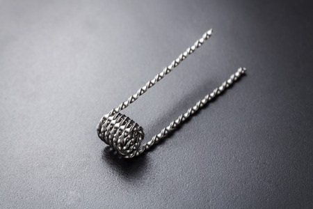 Ribbon twist coil for vaping on a black background macro closeup wire steel