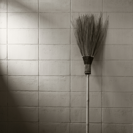 Garden broom on concrete wall background in the mood for old-time sepia tone.の写真素材
