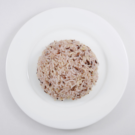 The cooked brown rice on the white plate.の写真素材