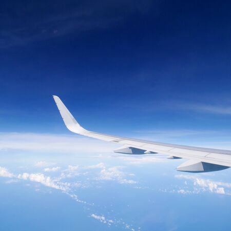 Wing of the airplane flying above a blue sky. 1の写真素材