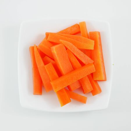 The fresh orange carrot sticks on the white small dish.の写真素材