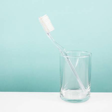 The clear toothbrush with small glass for brushing the teeth.の写真素材