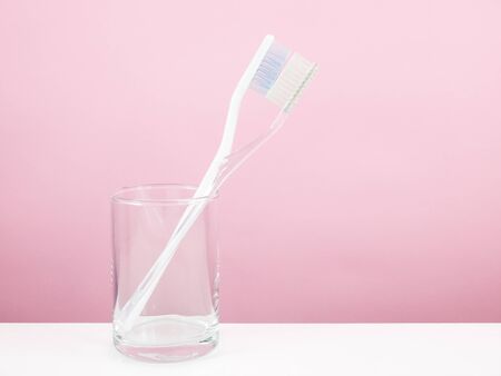 The white toothbrush with small glass for brushing the teeth.の写真素材