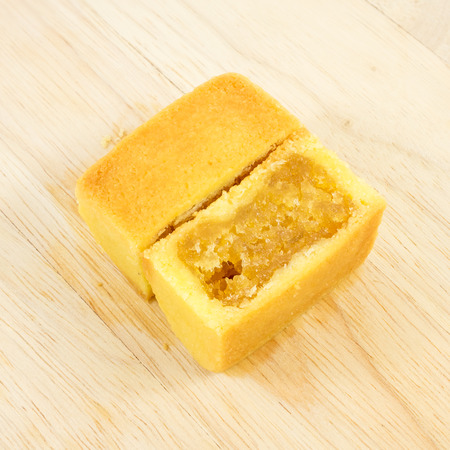 The tasty Taiwanese pineapple pastry cake with egg yolk on the wooden plank.の写真素材
