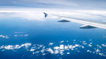 The airplane wing on the beautiful cloudy and sky.