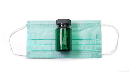 The close up of Anti-viral protection mask and Medicine bottle on white background.