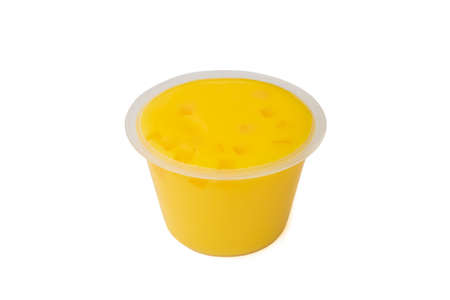 Yellow mango pudding, a close up of sweet mango mousse dessert in plastic cup isolated on white background.の写真素材