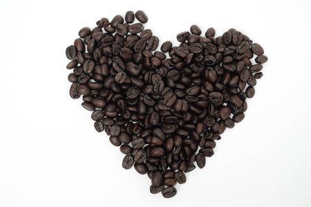 Old coffee bean in heart shape with white backgroundの写真素材