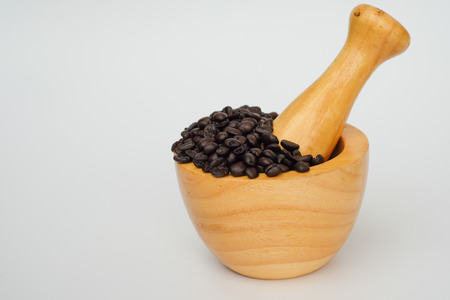 Old coffee beans in wood bowl with white backgroundの写真素材