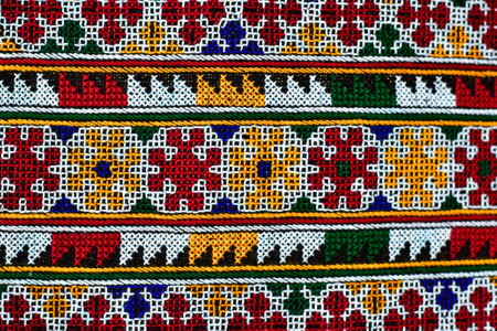 Hand-embroidered Yao Mien embroidery textile with colorful patterns, traditional tribal textile craft, intricate needlework, perfect for backgrounds, designs, and cultural art projects.の写真素材