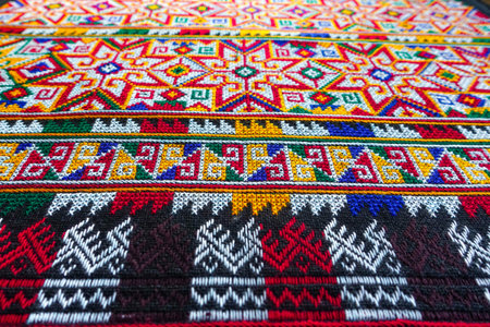 Hand-embroidered Yao Mien embroidery textile with colorful patterns, traditional tribal textile craft, intricate needlework, perfect for backgrounds, designs, and cultural art projects.の写真素材