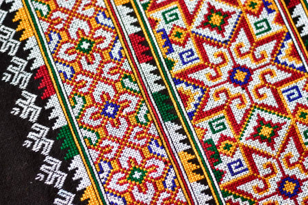 Hand-embroidered Yao Mien embroidery textile with colorful patterns, traditional tribal textile craft, intricate needlework, perfect for backgrounds, designs, and cultural art projects.の写真素材