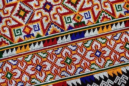 Hand-embroidered Yao Mien embroidery textile with colorful patterns, traditional tribal textile craft, intricate needlework, perfect for backgrounds, designs, and cultural art projects.の写真素材