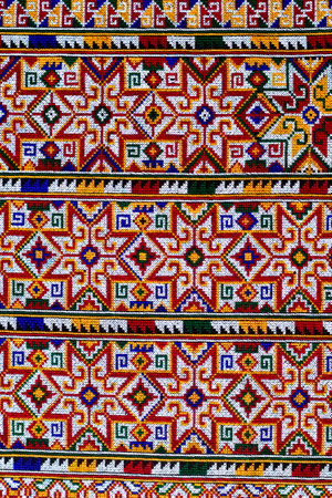 Hand-embroidered Yao Mien embroidery textile with colorful patterns, traditional tribal textile craft, intricate needlework, perfect for backgrounds, designs, and cultural art projects.の写真素材