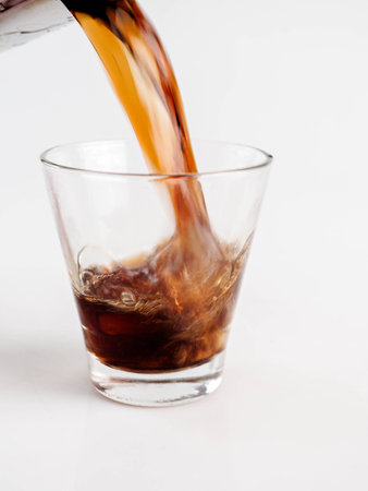 Pouring Cola with Ice in Glass on White Background.の写真素材