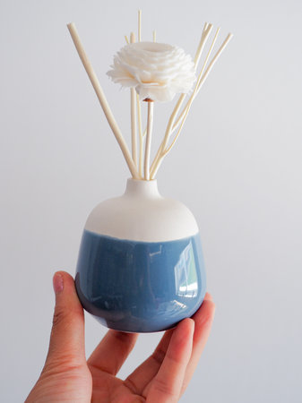 Hand Holding a Modern Minimalist Ceramic Vase with Color Block Design.