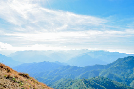 Scenic Mountain Landscape with Blue Sky and Layers of Misty Hillsの写真素材