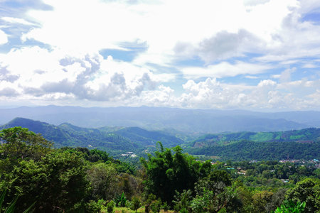 Scenic Mountain Landscape with Blue Sky and Layers of Misty Hillsの写真素材