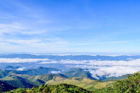 Scenic Mountain Landscape with Blue Sky and Layers of Misty Hillsの写真素材