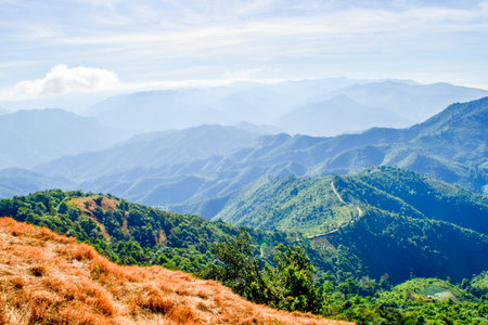 Scenic Mountain Landscape with Blue Sky and Layers of Misty Hillsの写真素材