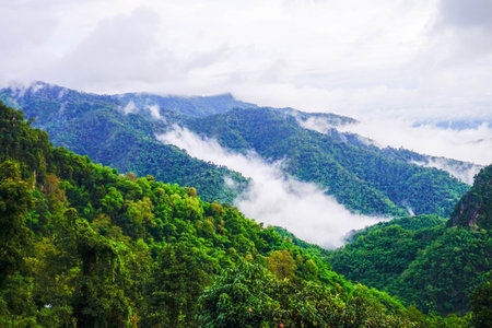 Scenic Mountain Landscape with Blue Sky and Layers of Misty Hillsの写真素材