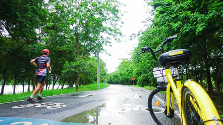 Man Running on Wet Road in Green Park After Rainの写真素材