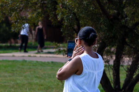Lady wearing white on a sunny day taking a selfie