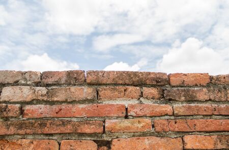 old cracked brick wall under sky backgroundの写真素材