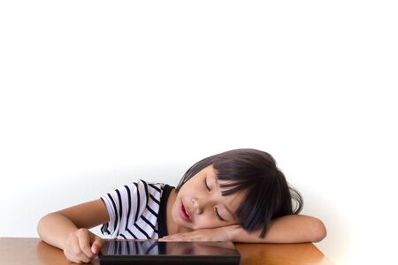 Little girl with bored tablet pc sitting on the wooden table - Technology and children conceptの写真素材