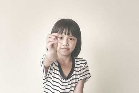 Joyful children girl with red chopsticks sitting at the table - Vintage Filter Effectの写真素材