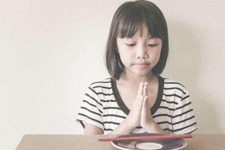 Thankful. Children girl fold her hands to Thank you God for my supper today - Vintage Filter Effectの写真素材