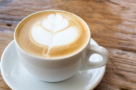 hot milk art coffee on wooden tableの写真素材
